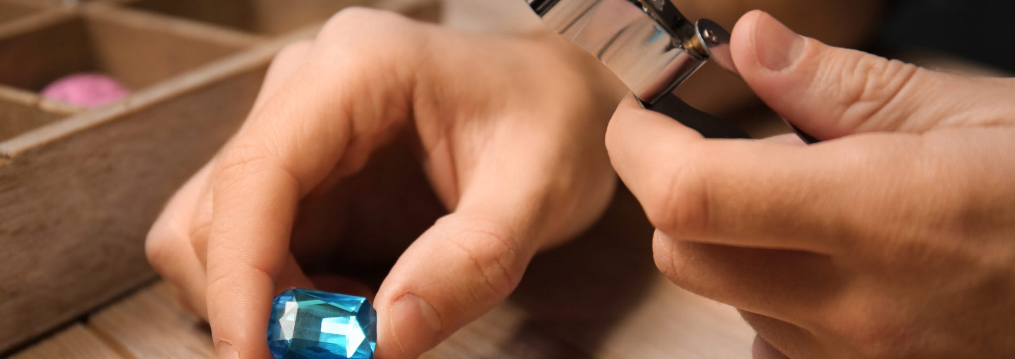 Jeweler examining gemstone in workshop, closeup