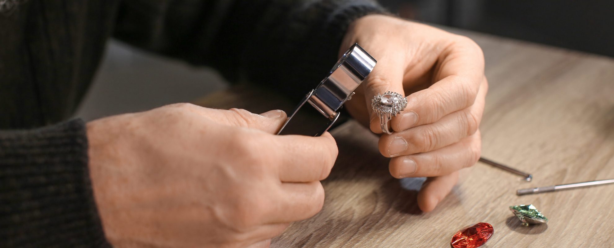 Jeweller examining adornment in workshop, closeup