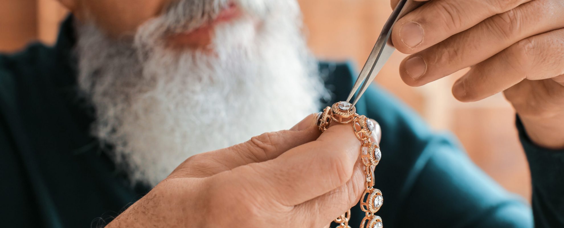 Jeweller examining adornment in workshop, closeup